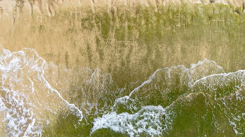 Early Hawaiian petroglyphs on a beach are visible again with changing tides and shifting sands